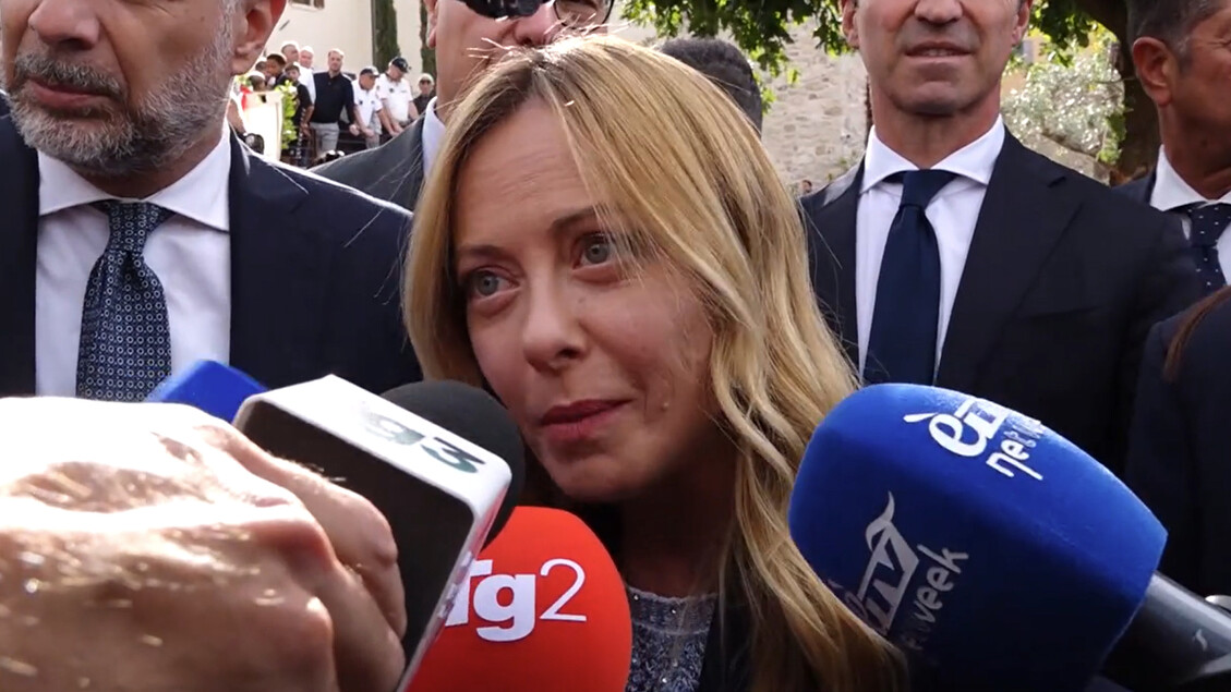 Giorgia Meloni &egrave; riconoscibile nell'immagine mentre parla in un microfono. &Egrave; presente una folla di persone. Meloni afferma: Ora gli italiani potranno scegliere tutto, anche i parlamentari. Altri uomini in abito sono visibili nella scena.