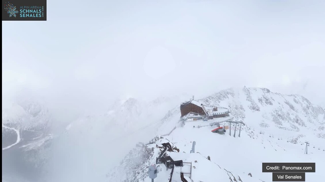 In Alto Adige, si osservano pioggia e neve, segnando l'arrivo dei 'Santi di Ghiaccio'. La scena presenta un edificio situato su una montagna, circondato da un paesaggio naturale invernale. La neve copre il terreno e le piste, creando un ambiente adatto per attivit&agrave; sportive all'aperto.