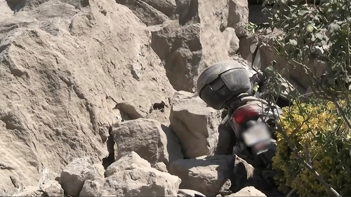 I Campi Flegrei mostrano la rabbia dei residenti a Pozzuoli, che lamentano l'assenza delle istituzioni. &Egrave; visibile una motocicletta appoggiata su delle rocce. Ci sono anche dettagli di rocce e piante nell'ambiente circostante. La scena si svolge all'aperto, in un contesto che suggerisce un'avventura. Un casco &egrave; presente come parte dell'equipaggiamento di protezione personale.