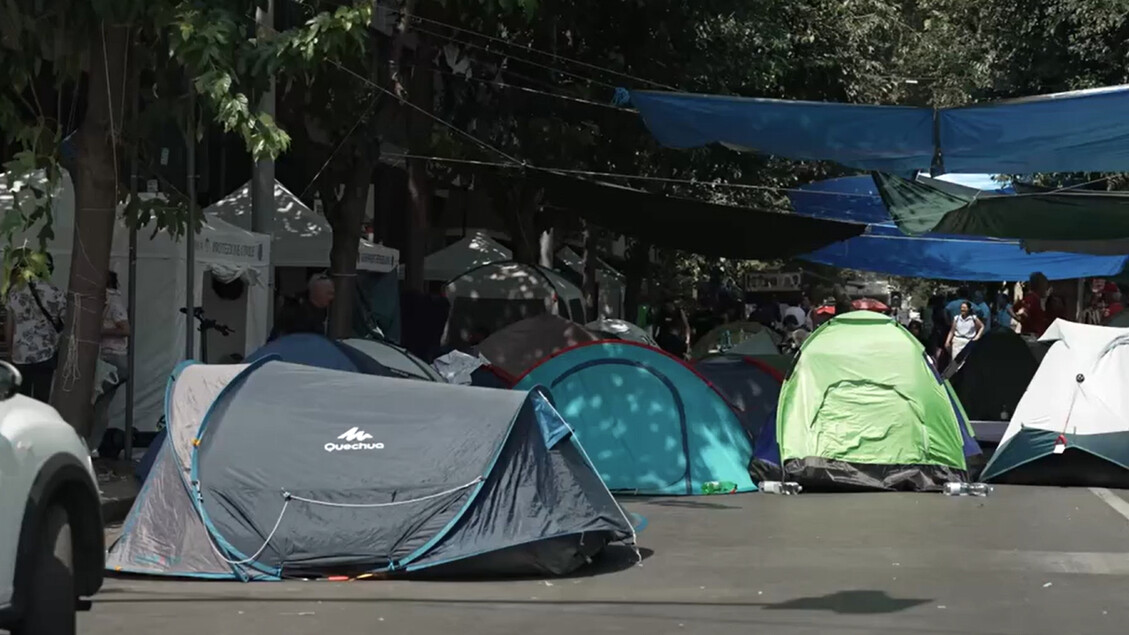 A Roma, si accentuano i disagi degli sfollati di Spin Time. Sono visibili diverse tende in strada, che indicano una situazione di emergenza. L'ambiente &egrave; all'aperto e il contesto suggerisce attivit&agrave; di campeggio.