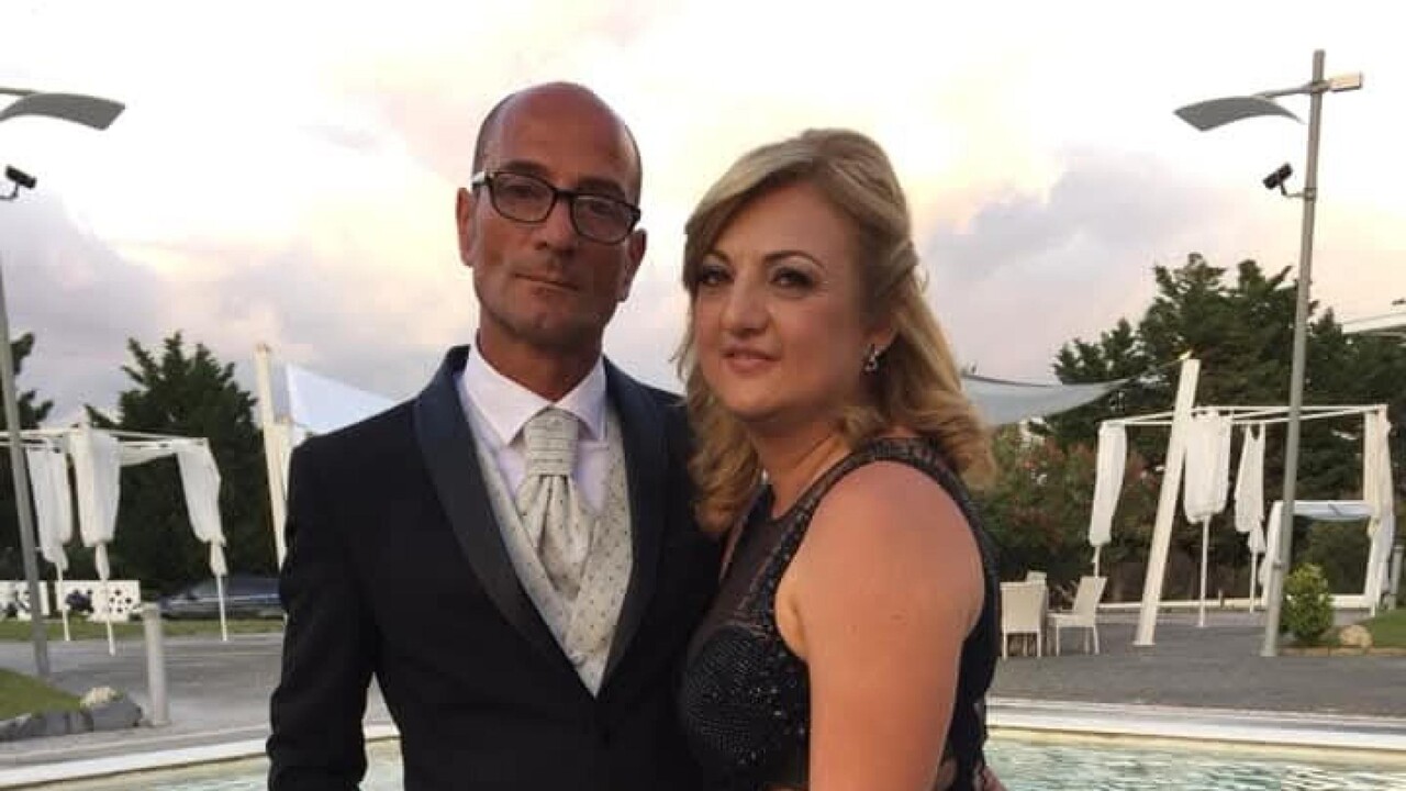 Un uomo e una donna indossano abiti formali. L'immagine &egrave; associata a un contesto di giustizia, poich&eacute; la moglie dell'operaio morto esprime il desiderio di ottenere giustizia. Gli abiti includono un completo e un vestito elegante.