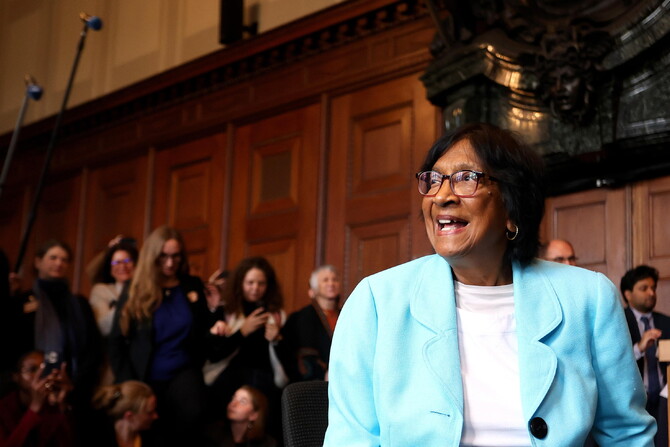 Navi Pillay, avvocato sudafricano, vince il Premio Nobel per la Pace 2026. Nell'immagine, &egrave; presente una donna che indossa un abito blu. Si trova in un ambiente interno, probabilmente durante un seminario o una conferenza, con un pubblico presente. La scena include persone e un'atmosfera di discussione formale.