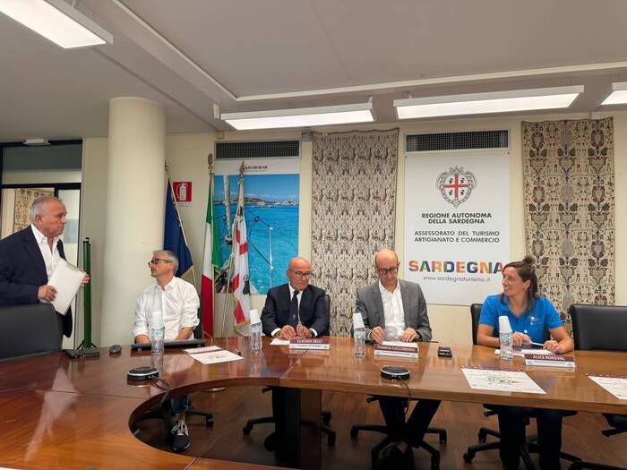 A Olbia si svolge una gara di boccia paralimpica in preparazione per Los Angeles 2028. Un gruppo di persone &egrave; seduto attorno a un tavolo in un ambiente interno, probabilmente durante un seminario o una riunione. &Egrave; presente un uomo in giacca che tiene un documento. Il contesto suggerisce un incontro di collaborazione o gestione, con un pubblico composto da adulti.