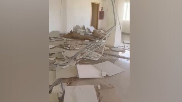 L'immagine mostra un istituto scolastico a Marsala, distrutto da una tromba marina. Le pareti bianche della stanza sono danneggiate e presentano segni di rottura. L'ambiente &egrave; interno e fa parte di un edificio scolastico.