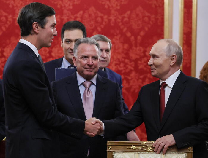 Nell'immagine si vede un gruppo di uomini che si stringono la mano. Vladimir Putin, Jared Kushner e Steve Witkoff sono riconoscibili nella scena. Gli uomini indossano abiti formali, tra cui giacche e cravatte. L'atmosfera suggerisce un incontro ufficiale, avvenuto a settembre 2026 in Russia.
