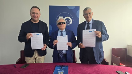 Un gruppo di uomini in abbigliamento formale tiene dei documenti. Sono presenti anche persone in un ambiente interno. Il contesto riguarda le barriere architettoniche e un'intesa tra Anci Campania, Fiaba e il Garante disabili.