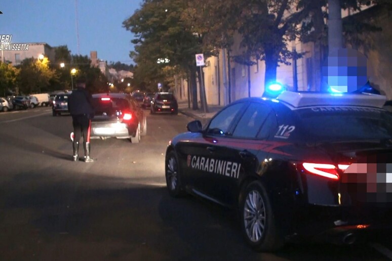 L'immagine rappresenta un'operazione della polizia nel Nisseno, con nove arresti legati alla mafia. &Egrave; visibile un'auto della polizia con le luci accese. Il contesto &egrave; caratterizzato da elementi di trasporto e veicoli, suggerendo un'azione di sicurezza pubblica. Sono presenti anche riferimenti ai Carabinieri e al numero di emergenza 112, che indicano l'importanza dell'intervento delle forze dell'ordine.