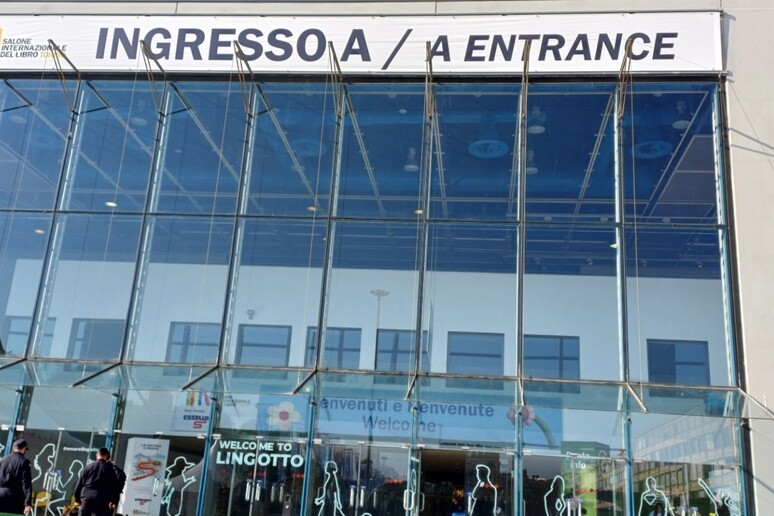 L'immagine mostra un grande edificio di vetro, che funge da centro congressi, situato al Salone del Libro di Torino. L'evento presenta l'Uici con Braille e audiolibri. &Egrave; visibile un'insegna che indica l'ingresso. L'architettura dell'edificio &egrave; moderna e si possono notare elementi come pannelli solari.