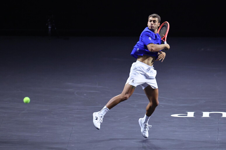Un uomo gioca a tennis durante la Laver Cup a Londra. Si vede un campo da tennis e l'uomo tiene una racchetta. L'evento &egrave; un incontro sportivo che coinvolge il tennis.