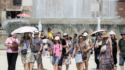 Un gruppo di persone cammina davanti a una fontana. La scena si svolge all'aperto, in un contesto urbano. Si osservano adulti, uomini e donne, alcuni indossano abbigliamento estivo. Domenica, 23 citt&agrave; avranno il bollino rosso per il caldo.